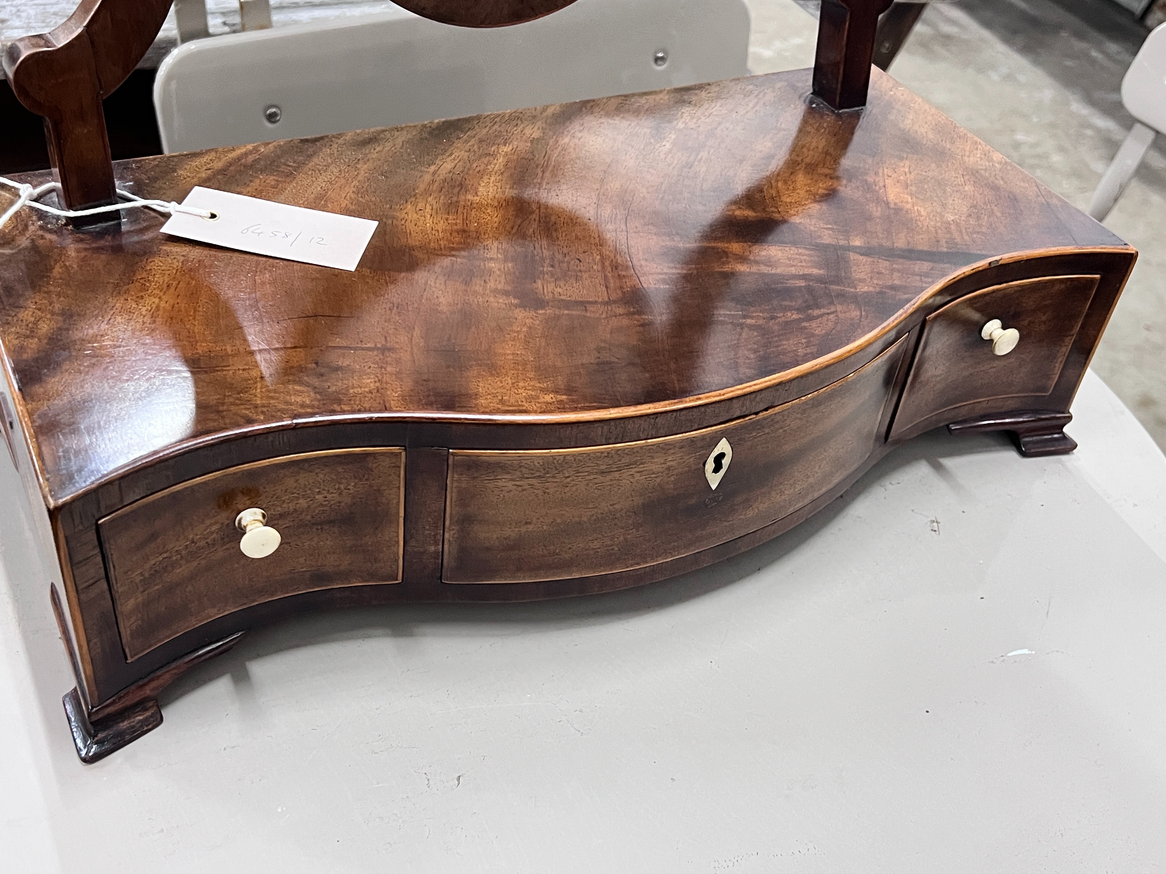 A George III serpentine mahogany box base toilet mirror, width 43cm, depth 21cm, height 57cm